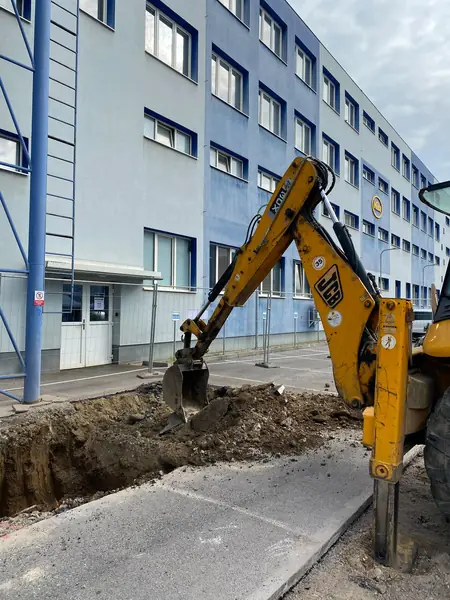 Bager JCB 3CX pri výkope popri hale v areáli závodu MIBA v Dolnom Kubíne