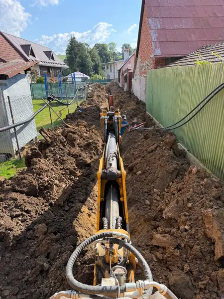 Prípojky elektriny, vody a kanalizácie + prístupová cesta, Istebné 10 Zásyp ryhy bagrom JCB 3CX po uložení prípojok
